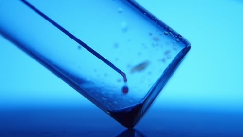 Needle Dispensing Liquid into Test Tube Macro Shot
