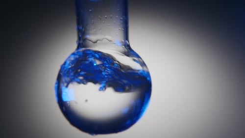 Lucid Water with Shining Tints Is Shaken in a Round Flask in a Chemical Lab