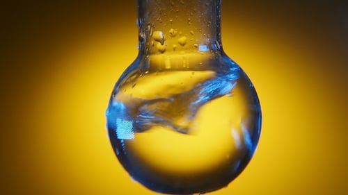Transparent Water with Blue Tints Is Shaken in a Round Bottom Flask in a Medical Lab