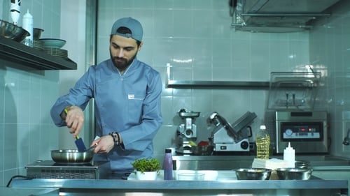 Male Chef Cooking Food in Commercial Kitchen