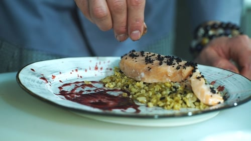Chef plating a gourmet salmon meal