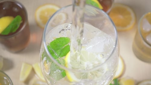 Pouring Sparkling Water into Lemon and Mint Drink
