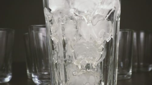 Water Pouring into Glass with Ice Cubes