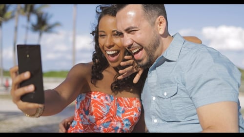 Joyful Couple Recording Video on a Sunny Beach