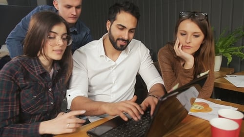 Team of Office Workers Before Laptop