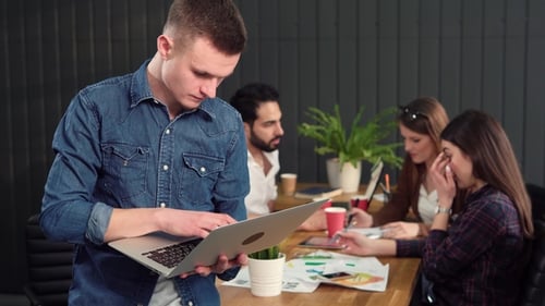 Man Uses Laptop in Office