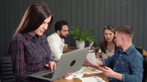 Smiling Woman Works on Laptop in Modern Office