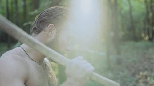 Porträt eines gutaussehenden bärtigen Mannes mit Axt im Wald