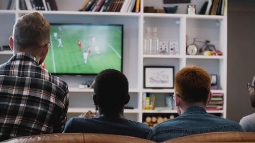 Four African American Guys Watch Football on TV. Back View. Excited Fans on the Couch Together