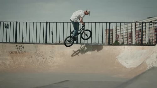 Male Performs BMX Tricks at Skatepark