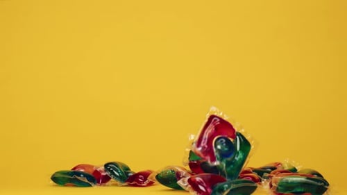 Laundry Pods Falling onto Yellow Background