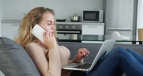 Young Woman Working From Home On Couch