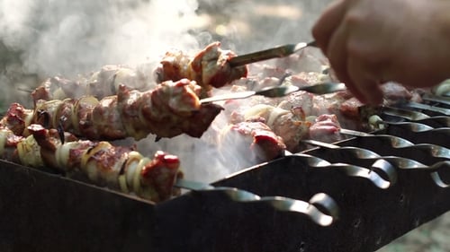 Man's Hands Rotating the Skewers. Shish kebab