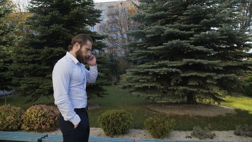 Handsome Man Makes a Call and Softly Talks on the Smartphone with Smile