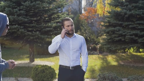 Rich Businessman Talks on a Phone and Runs Away a Poor Homeless Man