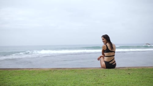 Woman Sits and Looks Out Over the Ocean