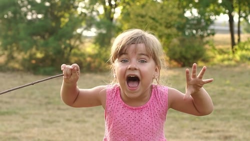 Little Girl Screams Loudly in the Park in Summer