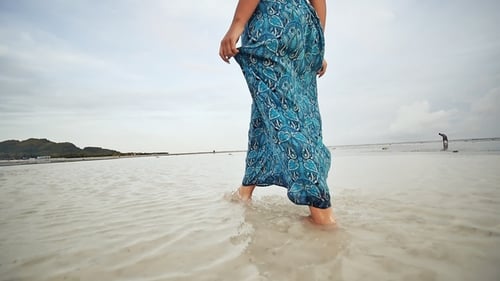 A Young Russian Girl with Happy Emotions Is Walking Along the Beach and Posing in Front of the