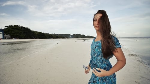 A Young Russian Girl with Happy Emotions Is Walking Along the Beach and Posing in Front of the