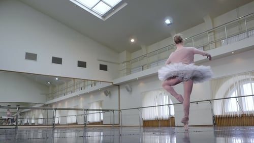 Ballerina in White Ballet Tutu Dress Performing Pirouettes in Dance Studio or Gym. Graceful Woman