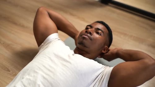 Top View of AfricanAmerican Man Practicing Abs Crunches Training Abdominal Muscles on Floor