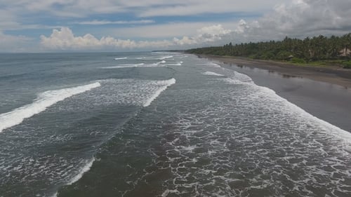 Tropischer exotischer Strand mit Vulkansand, blauer Himmel mit Wolken