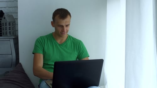 Young Adult Man Working on Laptop From Home