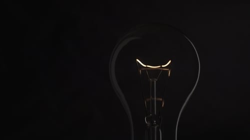 Ampoule sur fond noir. Ampoule Idea