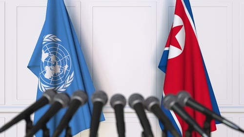 Flags of the United Nations and North Korea at International Press Conference