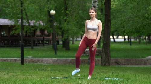 Young Girl Doing Yoga Exercises in the Park
