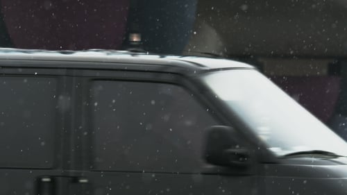 Snow Falling in a City with Passing Vehicle