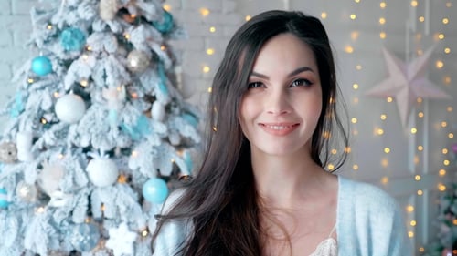 Smiling Woman in Front of Christmas Tree