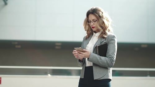 Professional Woman Using Smartphone in Modern Office