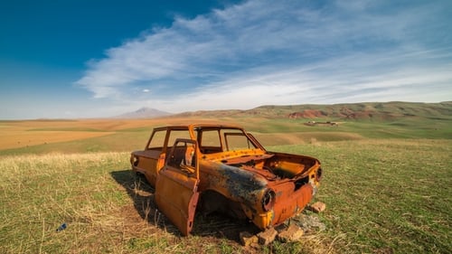 Old Orange Rust Retro Car at the Field and Blue Sky