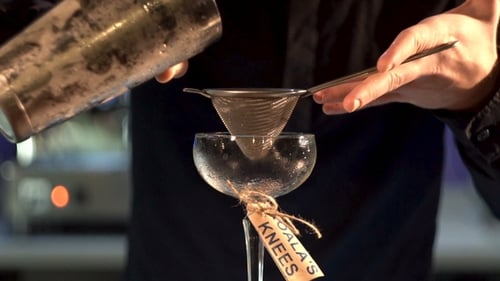 Bartender Strains Cocktail into Elegant Glass