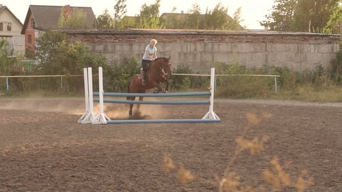 Girl Rider Jumps Over the Barrier at sunset