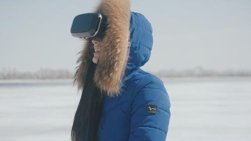 Smiling woman using virtual reality headset in winter