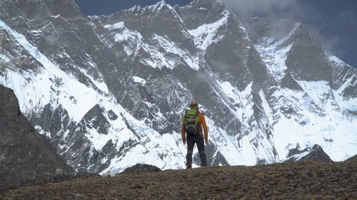Man with Backpack Climb the Mountain Slope in the Himalayas