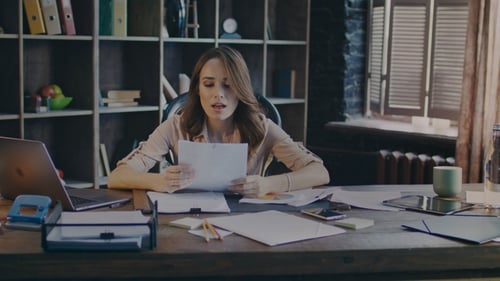 Woman Reviews Charts at Office Desk