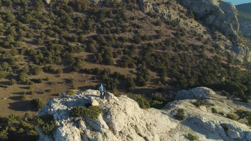 Climber Man Is Standing on Top of Rock and Raising Hands Victoriously