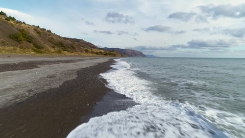 Extremely Low Angle Fast Drone Flying Forward Over Splashing Waves of Sea