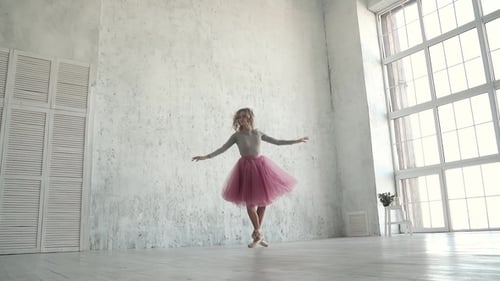 Young Ballerina Gracefully Dancing in Bright Studio