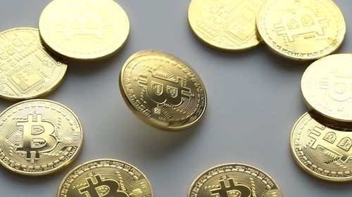 Coin golden bitcoin rotation, twist and falls on a golden background.