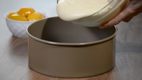 A Woman Pours the Dough Into a Baking Dish