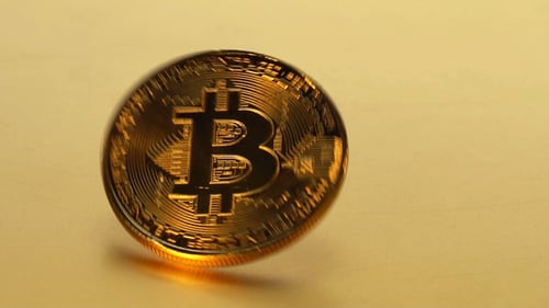 Coin golden bitcoin rotation, twist and falls on a golden background.