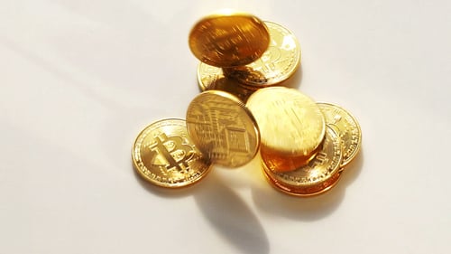 Bitcoin Coins Falling on a White Background