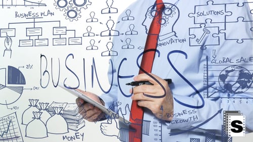 Businessman Planning Business Strategy on Glass Board