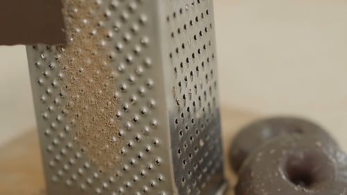 Chocolate being grated against a metal grater
