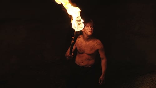 Careful Hermit with Burning Torch in Hand Walks and Looks Around in Stone Cave