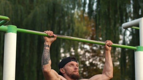 Muscular Man Doing Pull-ups on Horizontal Bar